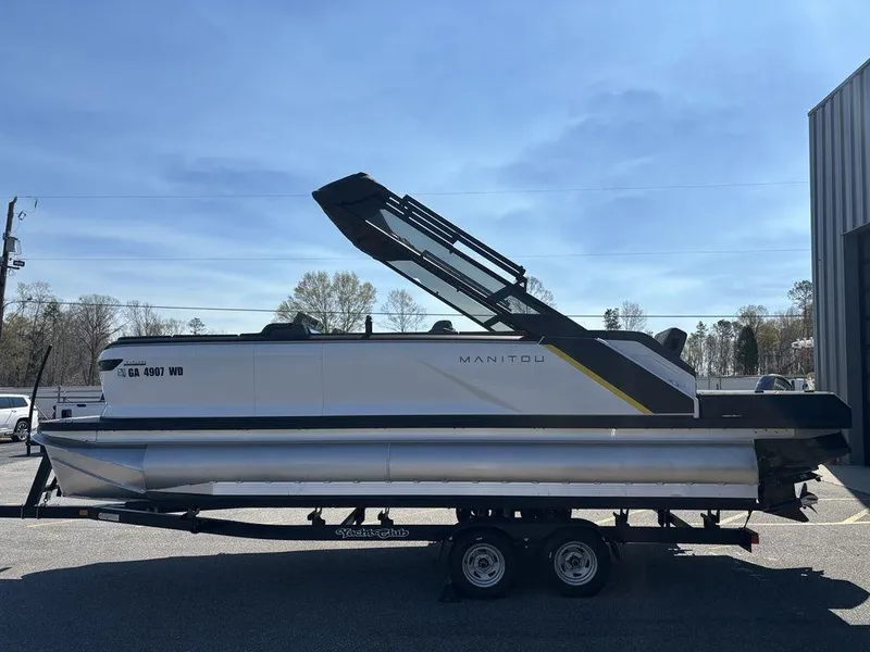 Slide: The Image of 2023 Manitou Explore 22 Max Bench pontoon boat on trailer, side view. - 18