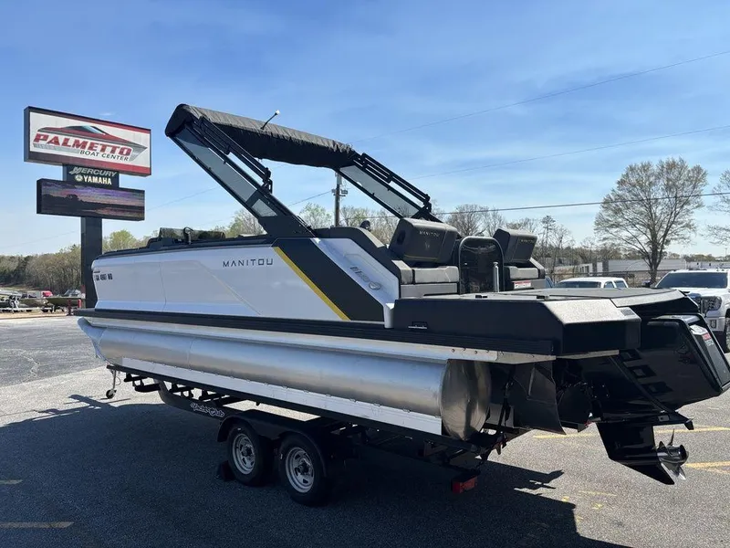 Slide: The Image of 2023 Manitou Explore 22 Max Bench pontoon boat on trailer at dealership. - 19