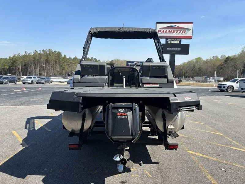 Slide: The Image of 2023 Manitou Explore 22 Max Bench pontoon boat with Rotax 150 engine, parked outdoors. - 20