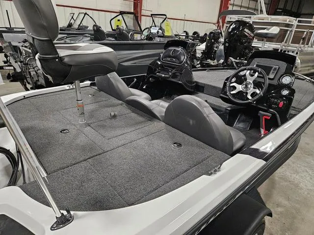 Slide: The Image of 2025 Nitro Z17 boat interior with seating, steering console, and carpeted deck in a showroom. - 8