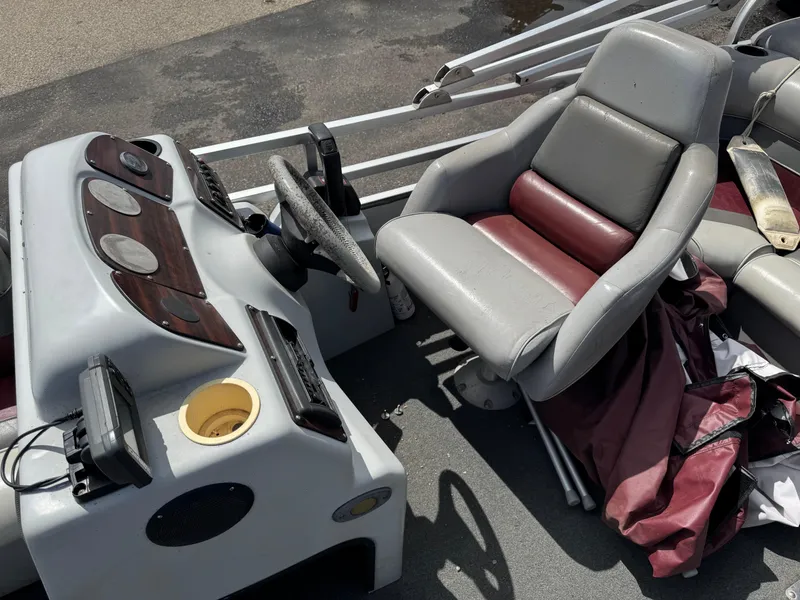 Slide: The Image of Boat interior with gray and maroon seats, steering wheel, and control panel, Paragon 2200SE 2001 model. - 9