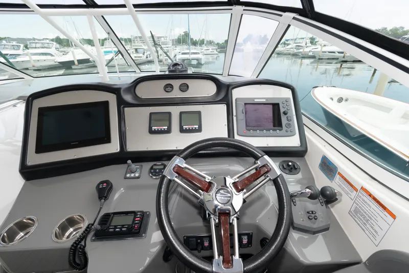 Slide: The Image of 2008 Cruisers Yachts 415 Express Motoryacht helm with modern navigation equipment and steering wheel. - 10