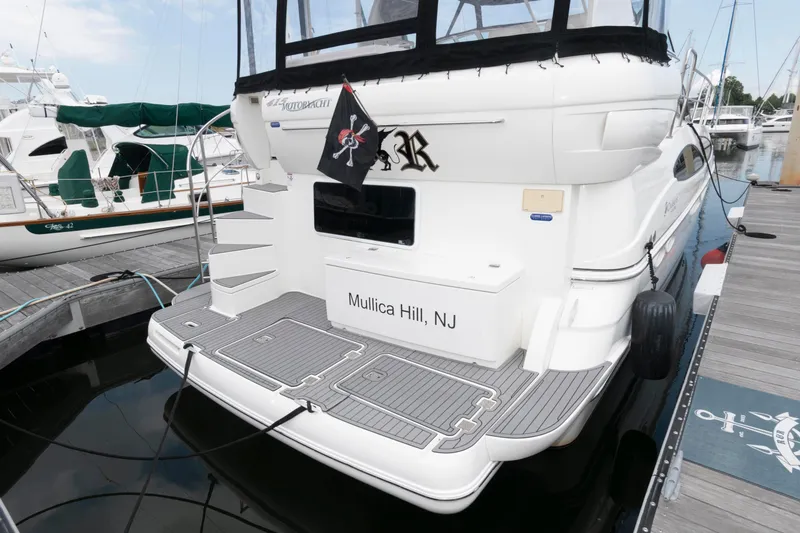 Slide: The Image of 2008 Cruisers Yachts 415 Express Motoryacht docked, featuring a sleek design and pirate flag. - 2