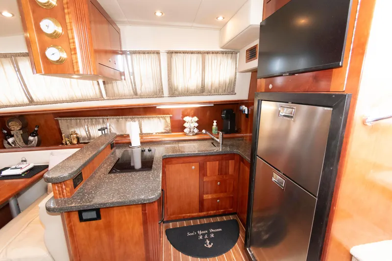 Slide: The Image of Luxurious 2008 Cruisers Yachts 415 Express Motoryacht kitchen with modern amenities and wood finishes. - 20
