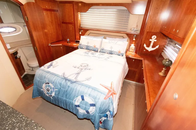 Slide: The Image of 2008 Cruisers Yachts 415 Express Motoryacht cabin with nautical-themed bedding and wooden interior. - 23