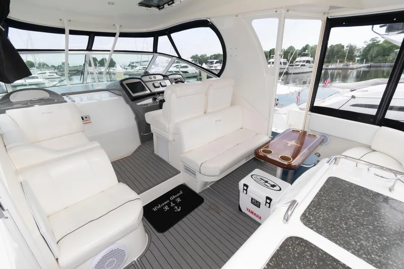 Slide: The Image of 2008 Cruisers Yachts 415 Express Motoryacht interior with white seating and helm, docked at marina. - 5