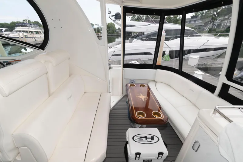 Slide: The Image of 2008 Cruisers Yachts 415 Express Motoryacht interior with white seating and wooden table. - 6