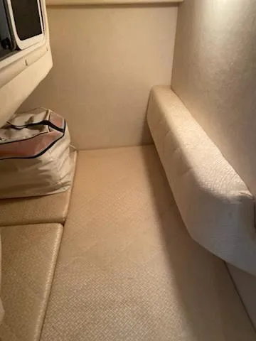 Slide: The Image of 2004 Sea Ray 260 Sundancer cabin interior with beige upholstery and storage bag. - 12