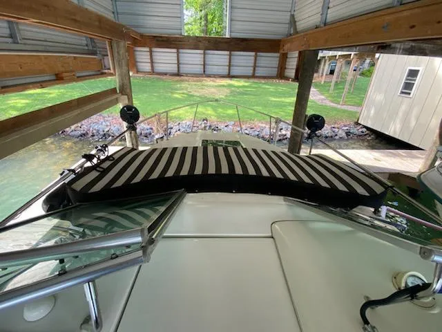 Slide: The Image of 2004 Sea Ray 260 Sundancer boat docked under shelter with striped cushion. - 16