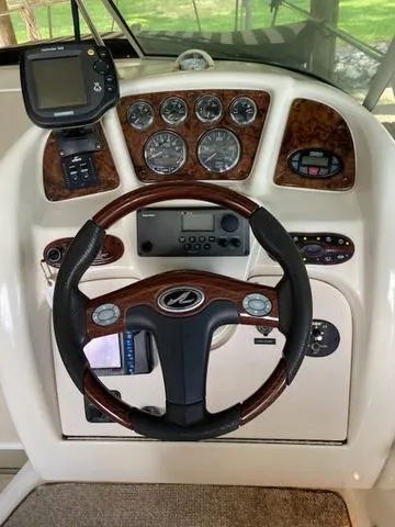 Slide: The Image of 2004 Sea Ray 260 Sundancer helm with gauges, steering wheel, and navigation equipment. - 9