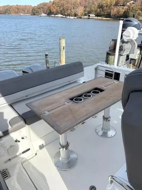 Slide: The Image of 2020 Jeanneau Leader 9.0 CC boat with wooden table and cup holders on deck. - 10