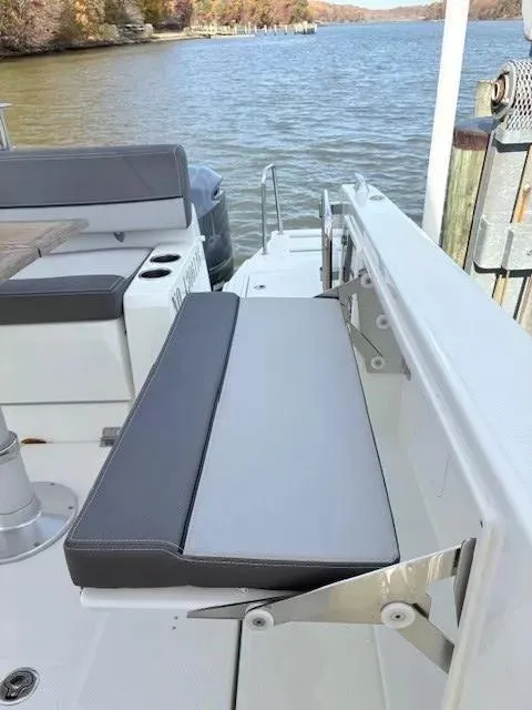 Slide: The Image of 2020 Jeanneau Leader 9.0 CC boat with foldable seating by the water. - 12