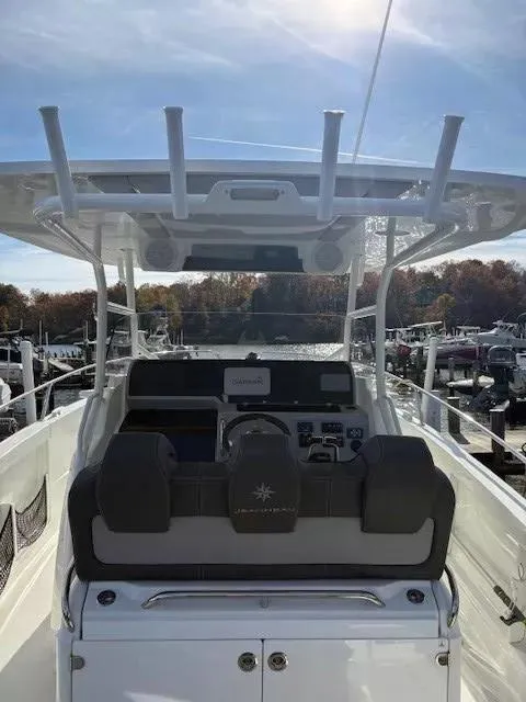 Slide: The Image of 2020 Jeanneau Leader 9.0 CC boat helm with modern controls and canopy in marina setting. - 14