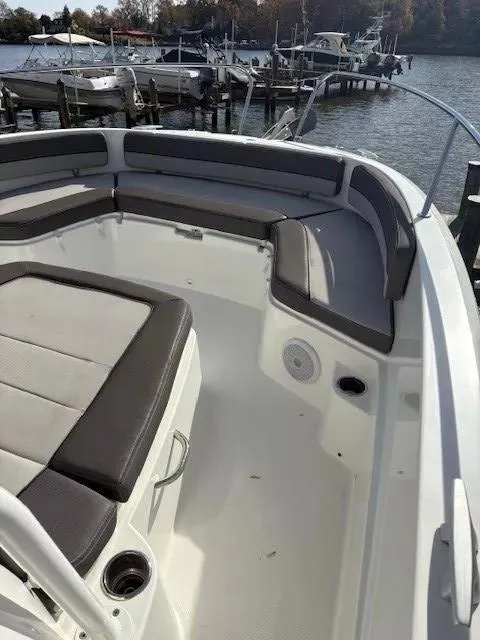 Slide: The Image of 2020 Jeanneau Leader 9.0 CC boat interior with cushioned seating and docked boats in background. - 23