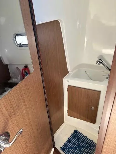 Slide: The Image of Interior of 2020 Jeanneau Leader 9.0 CC boat, featuring a compact bathroom with wooden accents. - 25