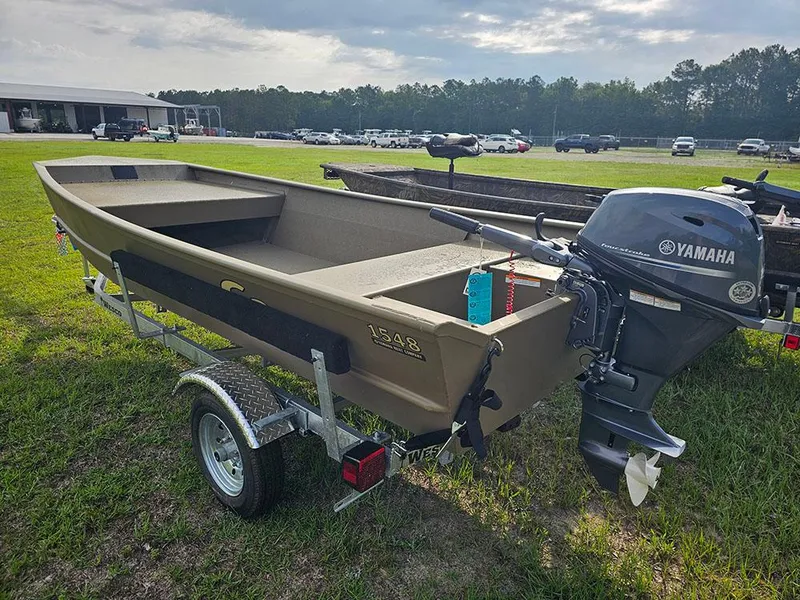 Slide: The Image of 2025 G3 Gator Tough 1548 VBW boat with Yamaha motor on trailer, parked on grass. - 2