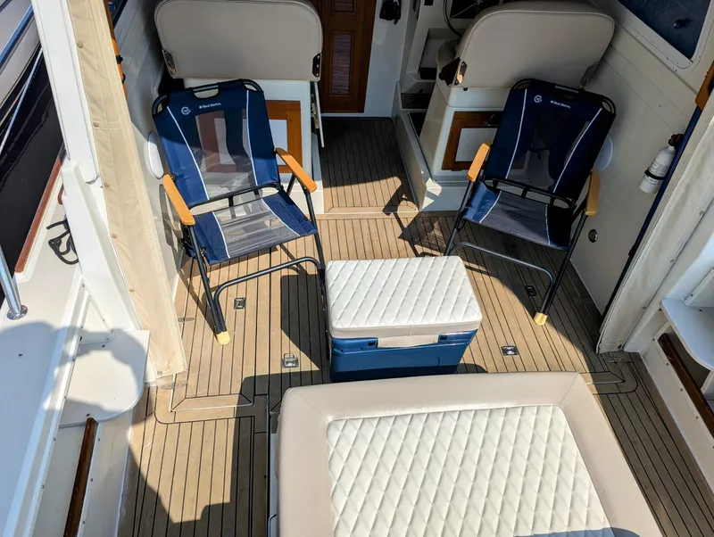 Slide: The Image of Interior of 2000 Hunt Yachts 29 with chairs and cooler on deck. - 11