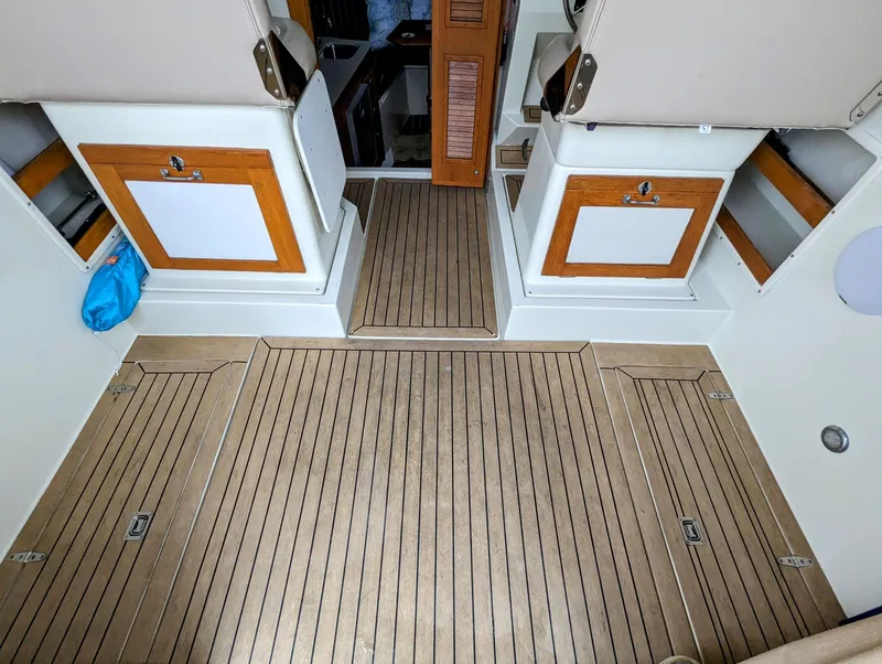 Slide: The Image of Interior of 2000 Hunt Yachts 29, featuring wooden flooring and seating compartments. - 15