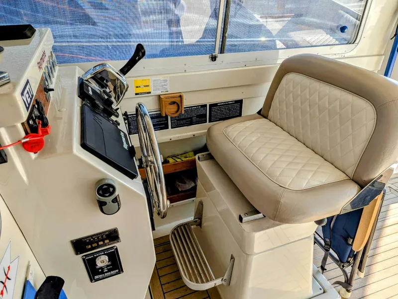 Slide: The Image of Helm station of 2000 Hunt Yachts 29 with cushioned seat and control panel. - 20