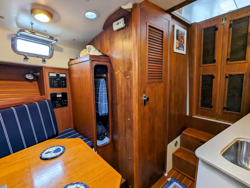 Slide: The Image of Interior of 2000 Hunt Yachts 29, featuring wood paneling, seating, and compact storage. - 30
