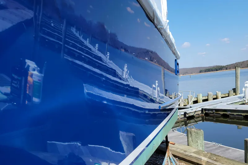 Slide: The Image of Hunt Yachts 29 (2000) with glossy blue hull reflecting dock and water. - 37