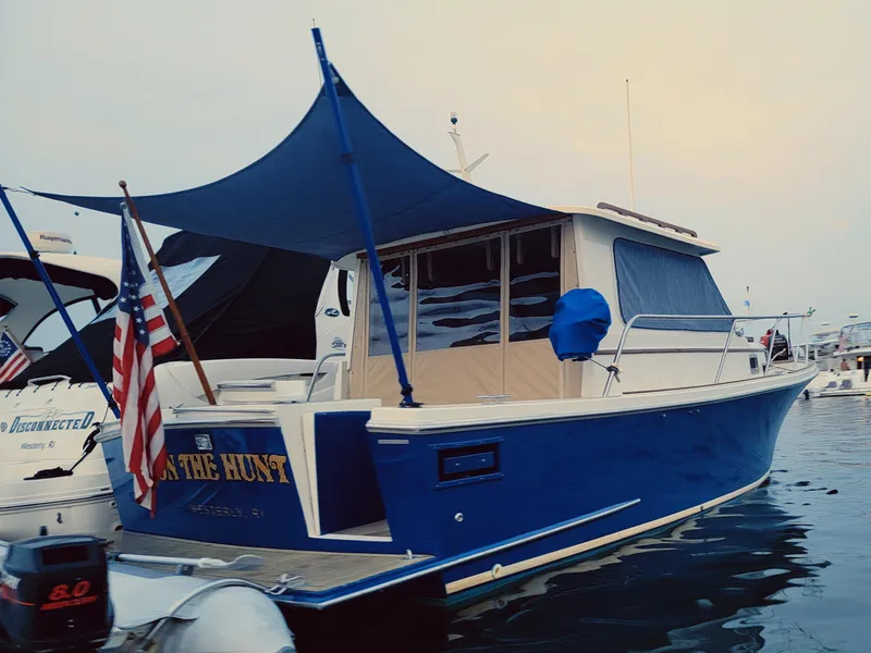 Slide: The Image of 2000 Hunt Yachts 29 boat with blue hull and canopy, docked in a marina. - 7