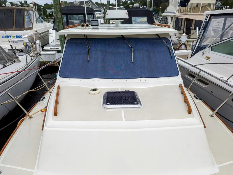 Slide: The Image of 2000 Hunt Yachts 29 docked, featuring a sleek deck and blue windshield cover. - 9