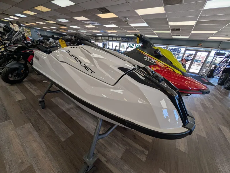 Slide: The Image of 2025 Yamaha Boats SUPERJET displayed in showroom, sleek white design, surrounded by other watercraft. - 12