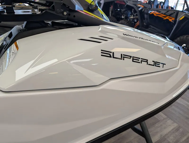 Slide: The Image of 2025 Yamaha Boats SUPERJET WaveRunner, sleek white design in showroom setting. - 3