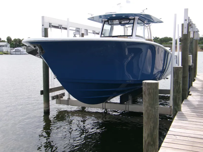 The Image of 2025 Sportsman Open 352 Center Console boat on lift by dock. - 0