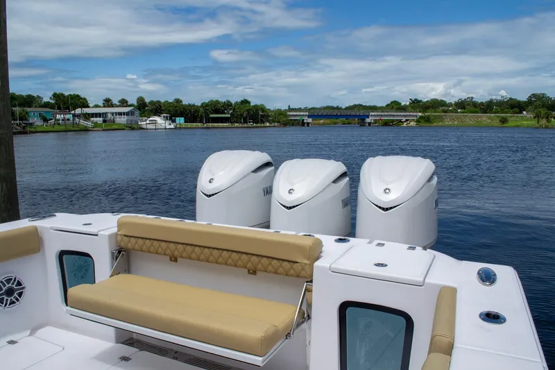 Slide: The Image of 2025 Sportsman Open 352 Center Console with triple engines on a serene lake. - 11