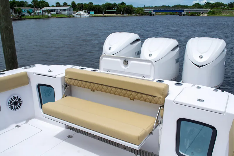 Slide: The Image of 2025 Sportsman Open 352 Center Console boat with triple engines and tan seating by the water. - 13