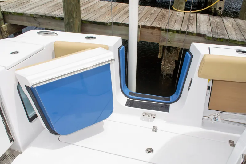 Slide: The Image of 2025 Sportsman Open 352 Center Console boat interior with blue and white seating near dock. - 17