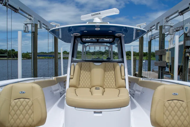 Slide: The Image of 2025 Sportsman Open 352 Center Console boat with tan seating, docked by the water. - 8