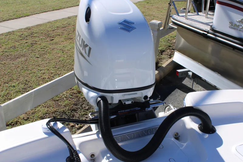 Slide: The Image of 2025 Sundance B20CCR boat with Suzuki outboard motor, docked on a sunny day. - 15