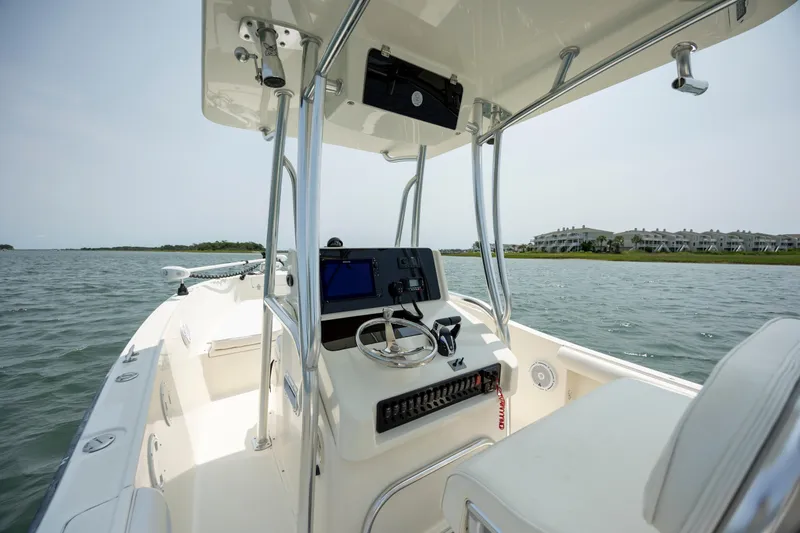 Slide: The Image of 2000 Pursuit 2470 Center Console boat on calm water, featuring a sleek helm and modern controls. - 17