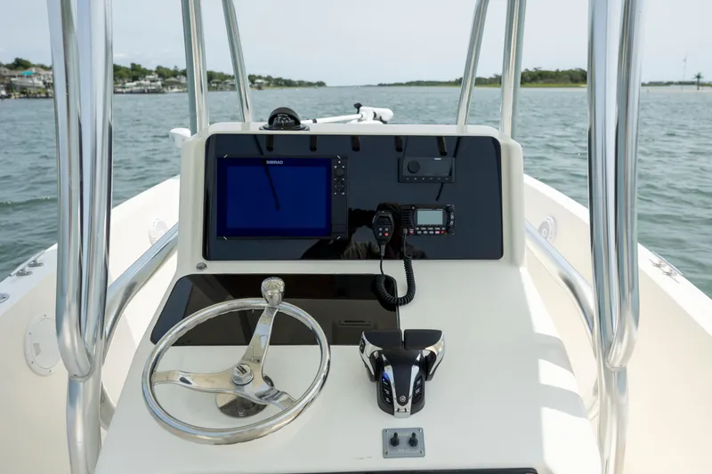 Slide: The Image of 2000 Pursuit 2470 Center Console boat dashboard with steering wheel and navigation equipment. - 18
