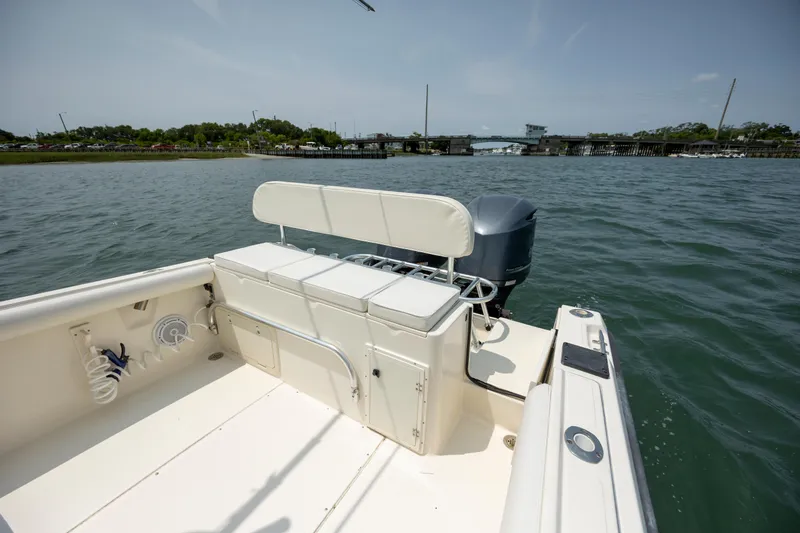 Slide: The Image of 2000 Pursuit 2470 Center Console boat on water, featuring spacious deck and seating. - 20