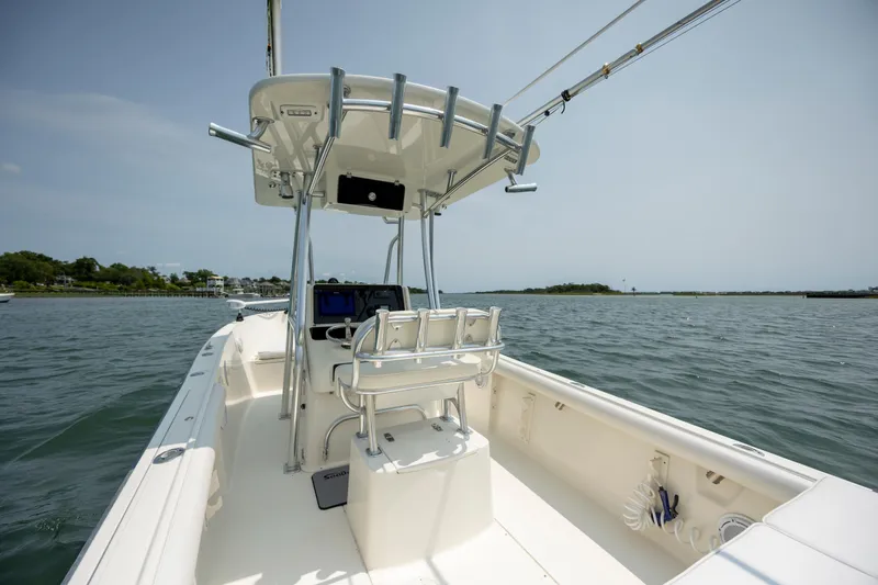 Slide: The Image of 2000 Pursuit 2470 Center Console boat on calm water, featuring a spacious deck and helm. - 23