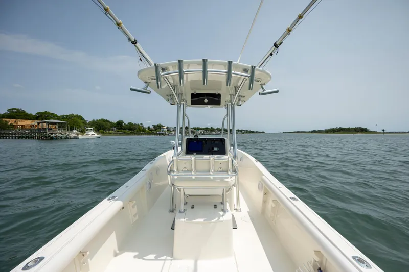 Slide: The Image of 2000 Pursuit 2470 Center Console boat on open water, clear sky, and distant shoreline. - 24