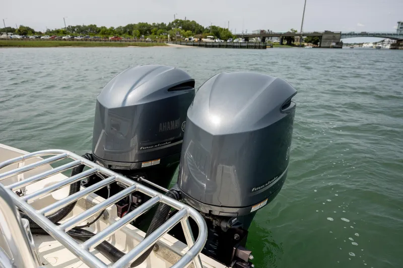 Slide: The Image of Twin Yamaha outboard motors on a 2000 Pursuit 2470 Center Console boat in a marina. - 25