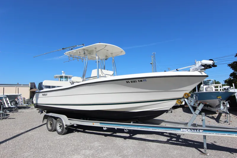 Slide: The Image of 2000 Pursuit 2470 Center Console boat on trailer under clear blue sky. - 26