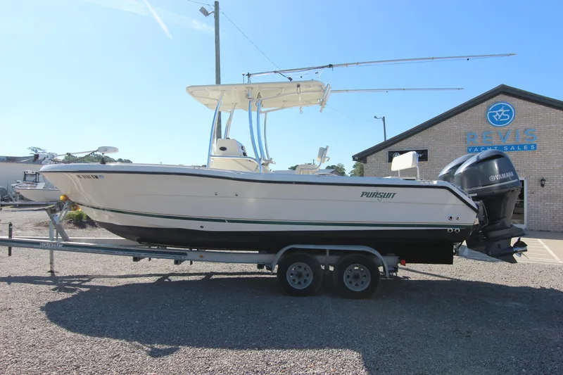Slide: The Image of 2000 Pursuit 2470 Center Console boat on trailer, parked outside a yacht sales building. - 30