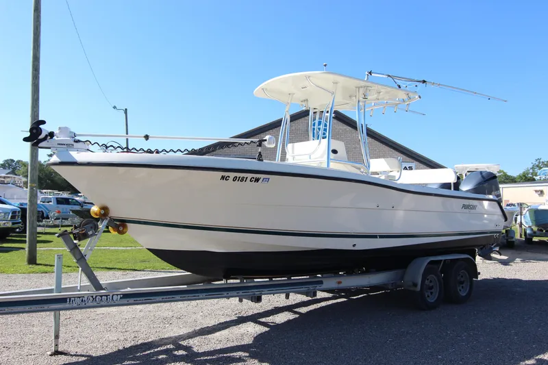 Slide: The Image of 2000 Pursuit 2470 Center Console boat on trailer, parked outdoors. - 31
