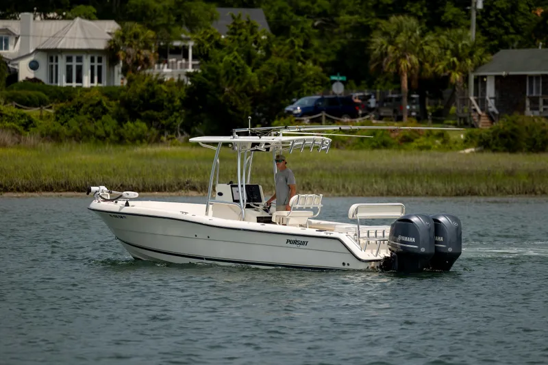 Slide: The Image of 2000 Pursuit 2470 Center Console boat cruising on a calm waterway. - 6
