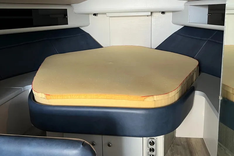 Slide: The Image of 1988 Silverton 34X Express cabin interior with a cushioned bed and blue accents. - 18