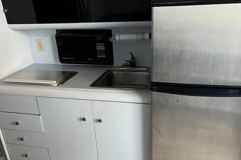 Slide: The Image of 1988 Silverton 34X Express kitchen with sink, microwave, and stainless steel refrigerator. - 19