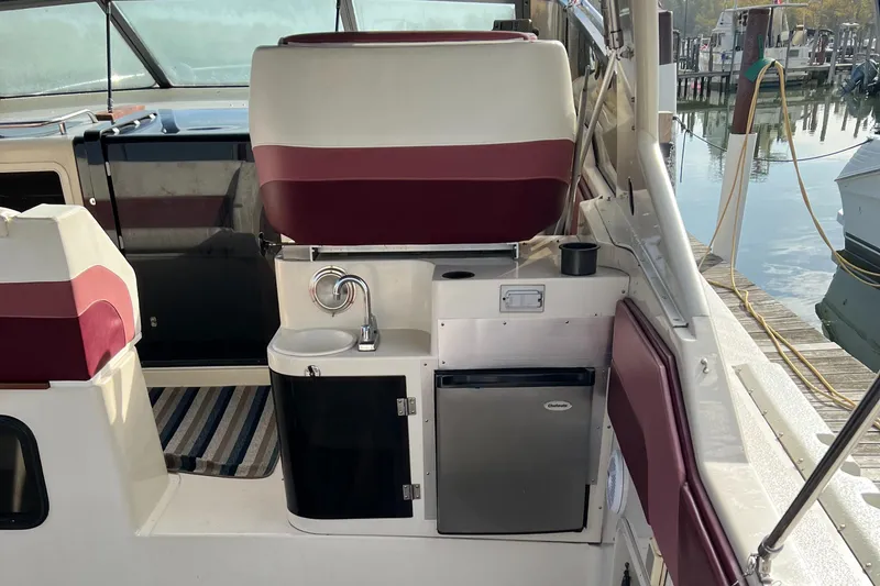 Slide: The Image of 1988 Silverton 34X Express boat interior with sink, mini fridge, and seating. - 7