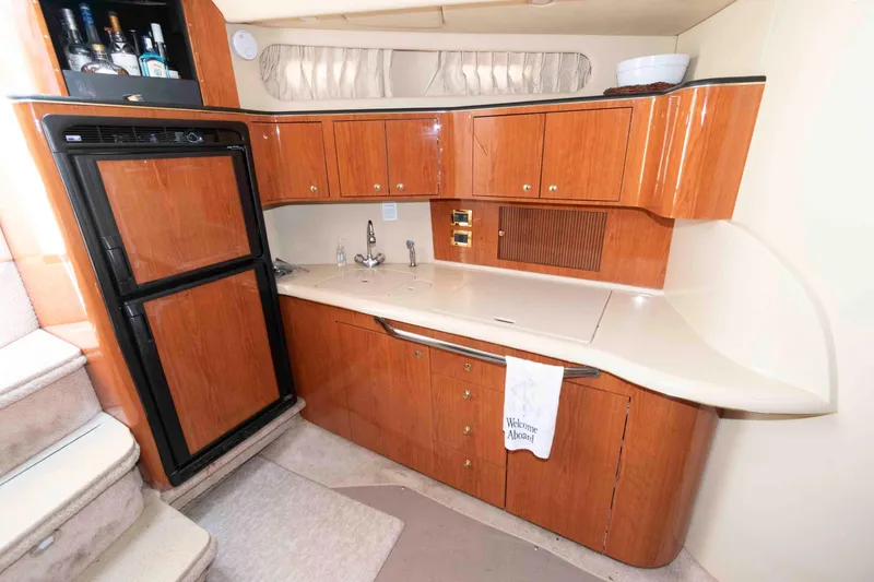 Slide: The Image of Interior of 2000 Sea Ray 410 Sundancer yacht kitchen with wood cabinets and appliances. - 9