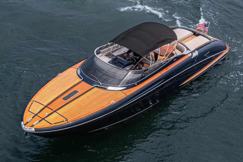 Slide: The Image of Luxury Riva 44 RivaRama yacht cruising on water, featuring sleek design and wooden deck. - 13